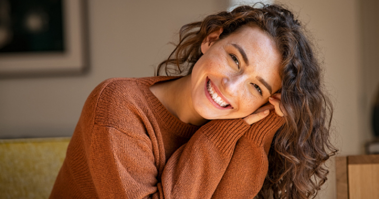 Happy young curly-haired woman smiling
